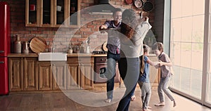 Emotional family having fun, dancing in pairs at home.