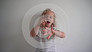 Emotional female kid counting her fingers over white background. Gimbal shot