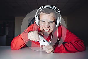 Emotional gamer plays home games on the joystick. The young man plays computer games using a gamepad.