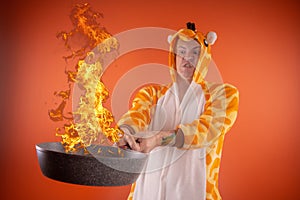 Emotional guy holding a frying pan in his hands, on an orange background.