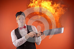 Emotional guy holding a frying pan in his hands, on an orange background.