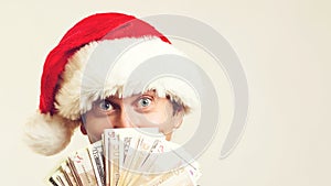 Emotional handsome guy holding money on a white background. Christmas, business and sales concept
