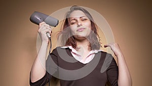 Emotional happy teenager girl make funny faces while drying her hair. Slow motion