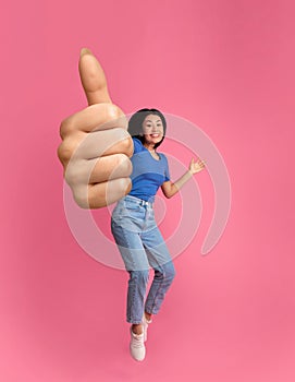 Emotional korean woman jumping up and showing thumb up