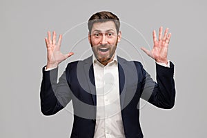 Emotional male business coach in suit puts his hands up and screams