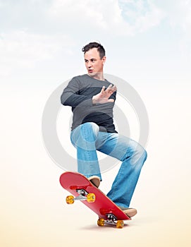 Emotional man in casual clothes performs a trick on a skateboard, on light background.