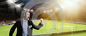 Emotional man, professional sport commentator, pressman during football match isolated over sport stadium background