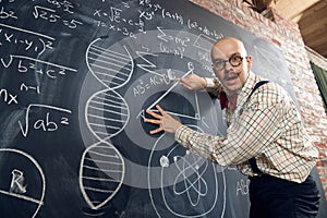 Emotional man, professor, scientist standing by blackboard with scientific formulas and calculations. Math, physics