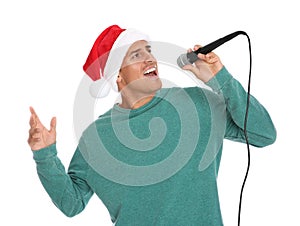 Emotional man in Santa Claus hat singing with microphone on white background. Christmas music