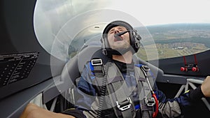 Emotional man sitting in jet cockpit making loop in the air, extreme hobby