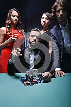 Emotional man in suit sitting at poker table and gesturing