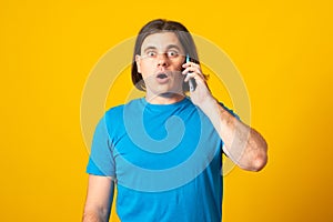 Emotional man surprised talking mobile phone discusses something actively