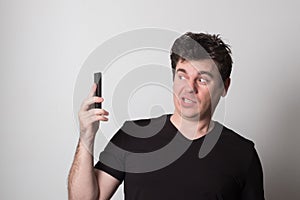 Emotional man talking on a cell phone. Caucasian young man screaming on the phone