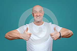 An emotional man in a white t-shirt shows with a hand gesture that everything is cool, on a Titian background