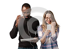 Emotional man and woman using gadgets on white studio background, technologies connecting people. Gaming, shopping