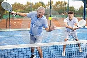 Emotional mature man playing doubles paddle tennis