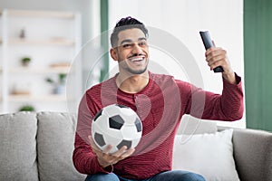 Emotional middle-eastern guy watching football game on TV