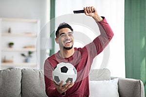 Emotional middle-eastern man watching football match on TV