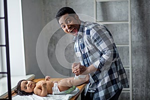 Emotional nervous frightened dad is changing his baby diaper, close-up photo