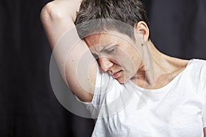 Emotional portrait of an adult woman with short hair and closed eyes. Close-up. Black background