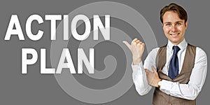 Emotional portrait of businessman showing right hand gesture on text - ACTION PLAN. Gray background