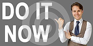 Emotional portrait of businessman showing right hand gesture on text - DO IT NOW. Gray background
