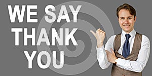 Emotional portrait of businessman showing right hand gesture on text - WE SAY THANK YOU. Gray background