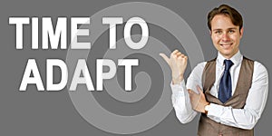 Emotional portrait of businessman showing right hand gesture on text - TIME TO ADAPT. Gray background