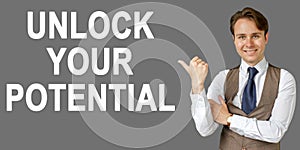 Emotional portrait of businessman showing right hand gesture on text - UNLOCK YOUR POTENTIAL. Gray background
