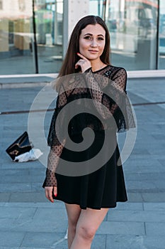 Emotional portrait of Fashion stylish portrait of pretty young woman. city portrait. sad girl. brunette in a black dress. expectat