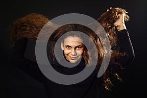 Emotional portrait of a girl with long curly hair on background