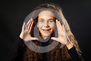 Emotional portrait of a girl with long curly hair on background