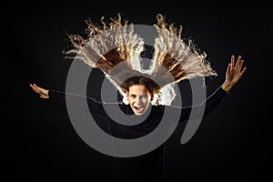 Emotional portrait of a girl with long curly hair on a black background