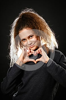 Emotional portrait of a girl with long curly hair on a black background