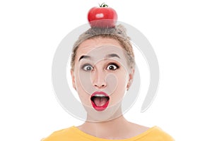 Emotional portrait of a girl with a tomato on an isolated white background in studio. The concept of a healthy diet