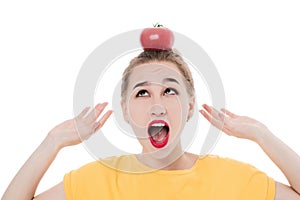 Emotional portrait of a girl with a tomato on an isolated white background in studio. The concept of a healthy diet