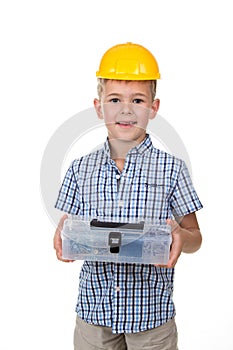 Emotional portrait of handsome boy wearing blue checkered shirt and yellow hard hat, holding toolbox, isolated on white