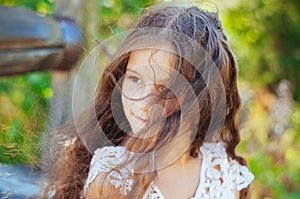 Emotional portrait of a little girl with long hair, summer day