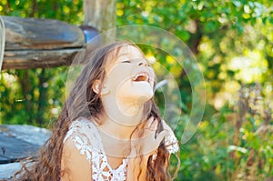 Emotional portrait of a little girl with long hair, summer day