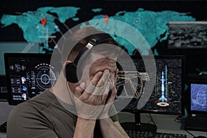 Emotional portrait of a military specialist in headphones, computer monitors. Concept: rocket launch, human observation, analytica photo