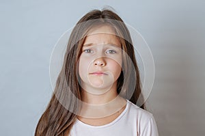 Emotional portrait of strong emotions tears of a little beautiful girl on a white background
