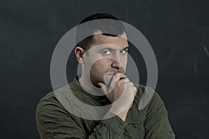 Emotional portrait of a thoughtful man 30-35 years old on a black background.