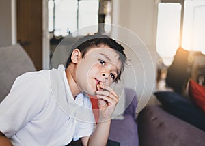 Emotional portrait young boy looking out deep in thought while eating nut, Cinematic portrait Child sitting alone with thinking