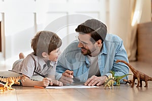 Emotional positive father involved in funny domestic activity with son.