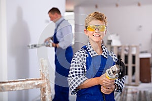 Emotional preteen boy posing with grinder machine