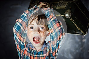 Emotional red-haired boy with suitcase