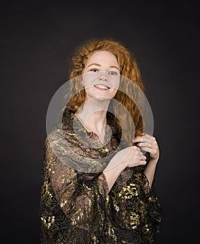 Emotional, red-haired girl in a brocade blouse posing