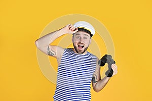 Emotional sailor with binoculars on yellow