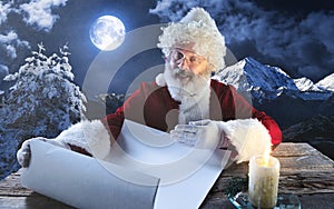 Emotional Santa Claus congratulating with New Year and Christmas, writing a letter, wish list in midnight with candle