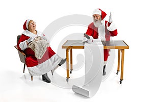 Emotional Santa Claus and his wife, missis Claus congratulating with New Year and Christmas, writing a letter, wish list